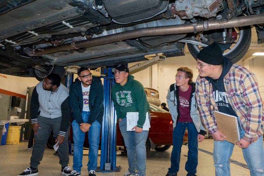 Students in the auto technology program examine the underside of a vehicle.