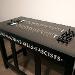 Macha Suzuki, “Untitled (Communion Table),” 2022. Found table, wood, guitar hardware. 30 x 42 x 20 inches.