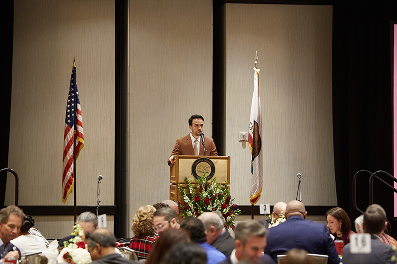 Mark Vidal, Director of Marketing & Public Relations speaking at the podium.
