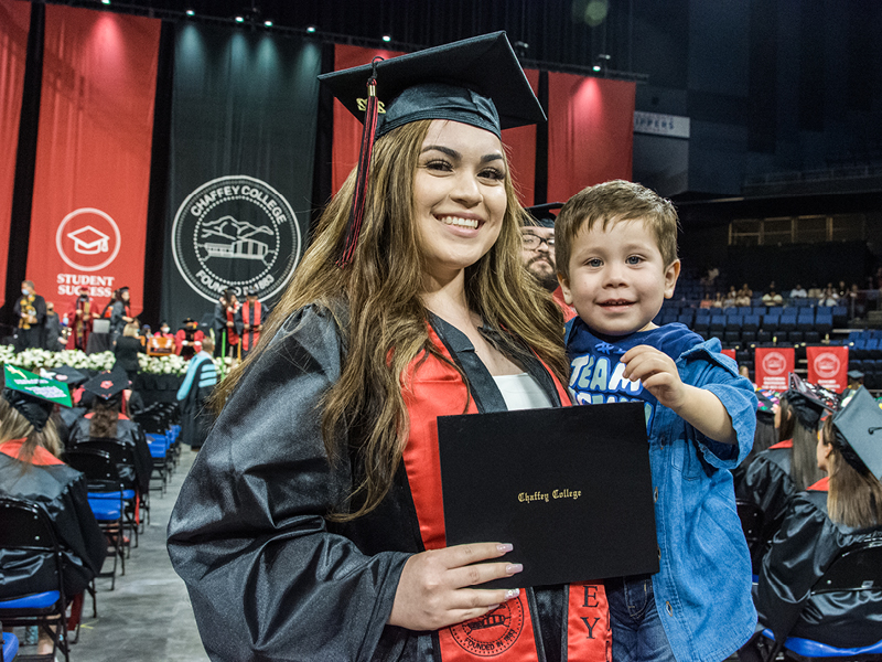 Graduate student and a child at the commencement ceremony.