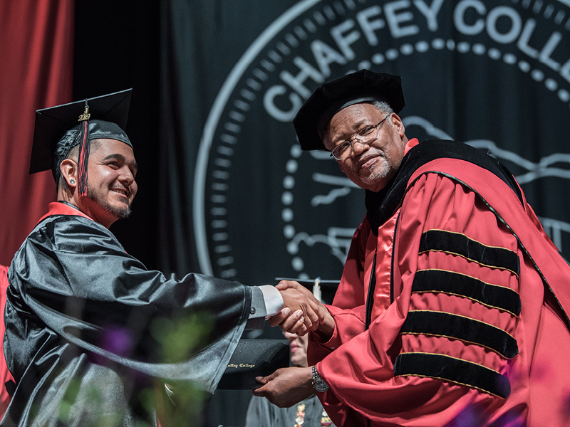 Commencement ceremony - Dr. Shannon handing diploma to a graduate student.