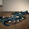Alexa Rand, “Along the River,” 2023. Crocheted yarn, fired & glazed clay, black river stones, and fiber fill. Approximately 8 x 4 feet.