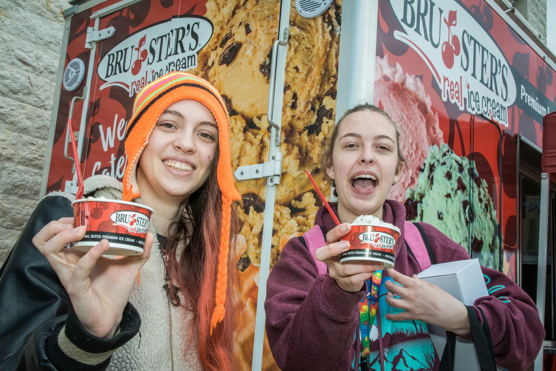 Two students holding each a cup of ice scream