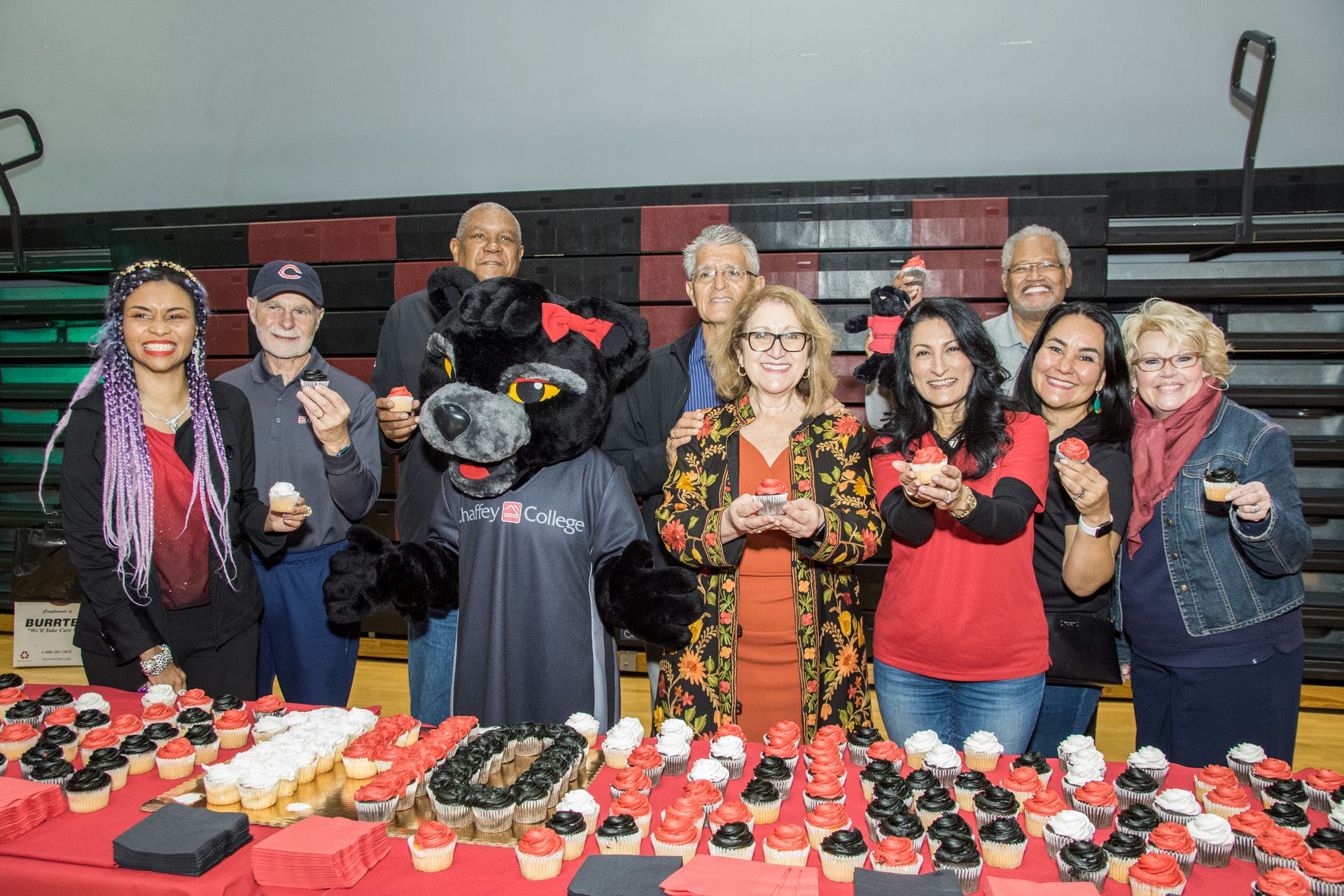Chaffey College staff members holding cup cakes