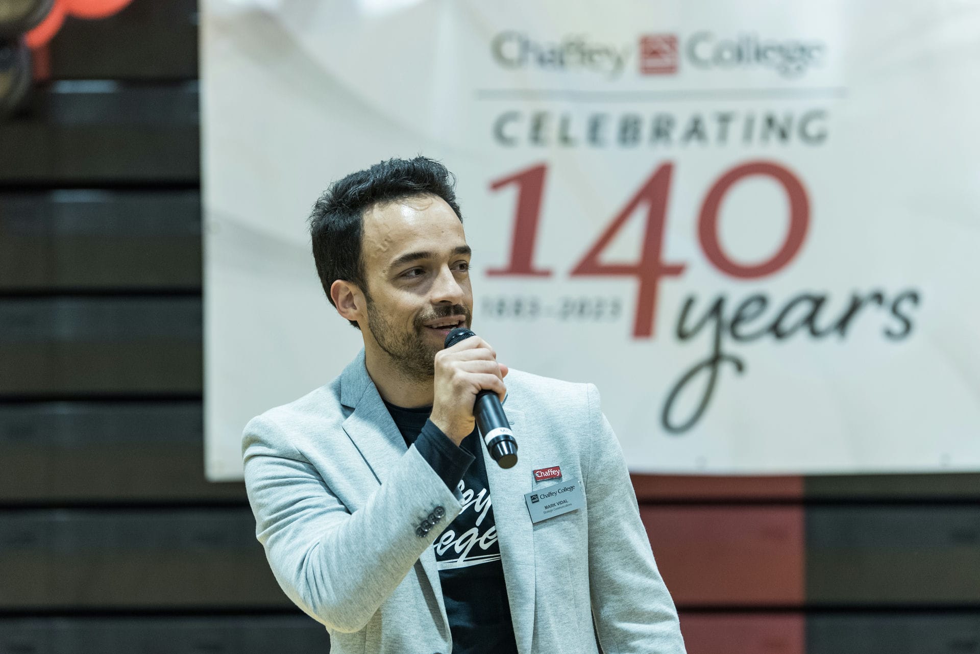 Mark Vidal, Director of Marketing and Public Relations holding a microphone.