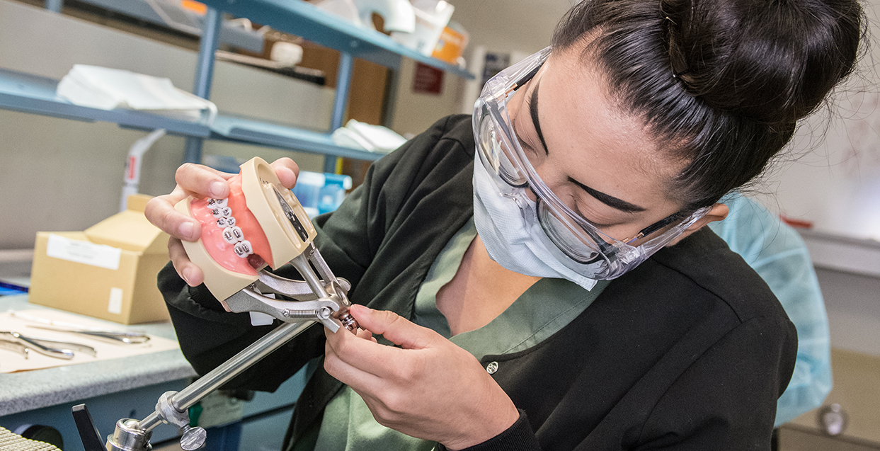 Dental assisting student working on denture