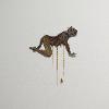 Melanie Brewster, “wolfmotherhood,” 2025. Wall mounted glazed ceramic with 24k gold luster and gold chains. 17 x 15 inches.
