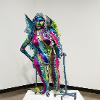 A. Laura Brody, “The Fairy Melusine,” 2023. Reused walker, textiles, and notions over plastics, cartons and wire. 98 x 42 x 36 inches.