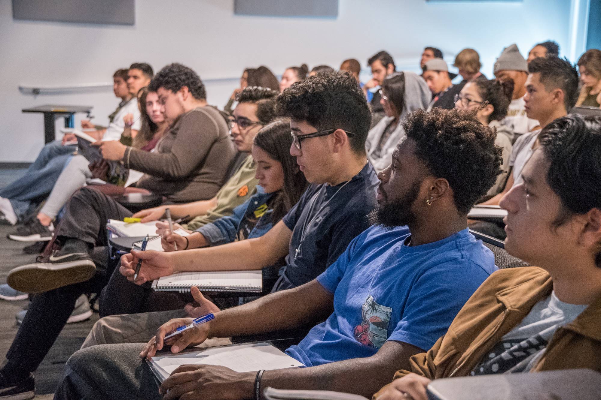 Students in an art class listen to the instructor.