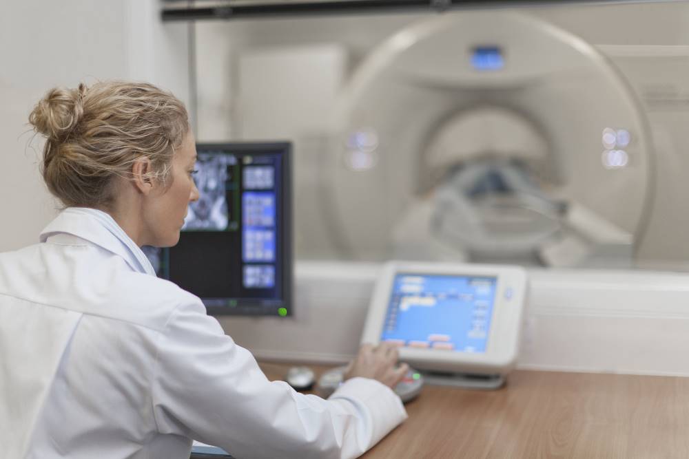 A CT technologist uses computed tomography equipment.