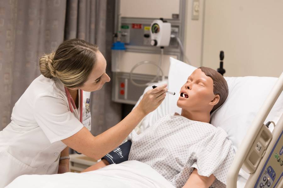 A nursing student works in a lab environment.