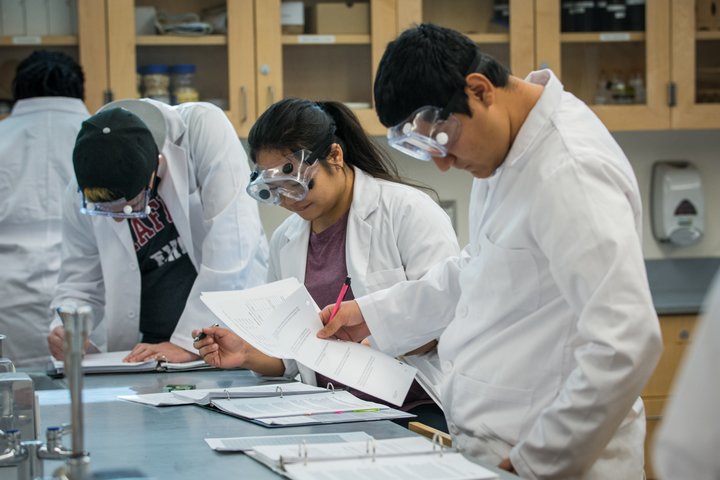 Students examine a slide in chemistry class.