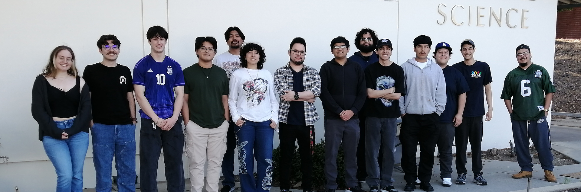 A group of engineering students pose in a classroom.