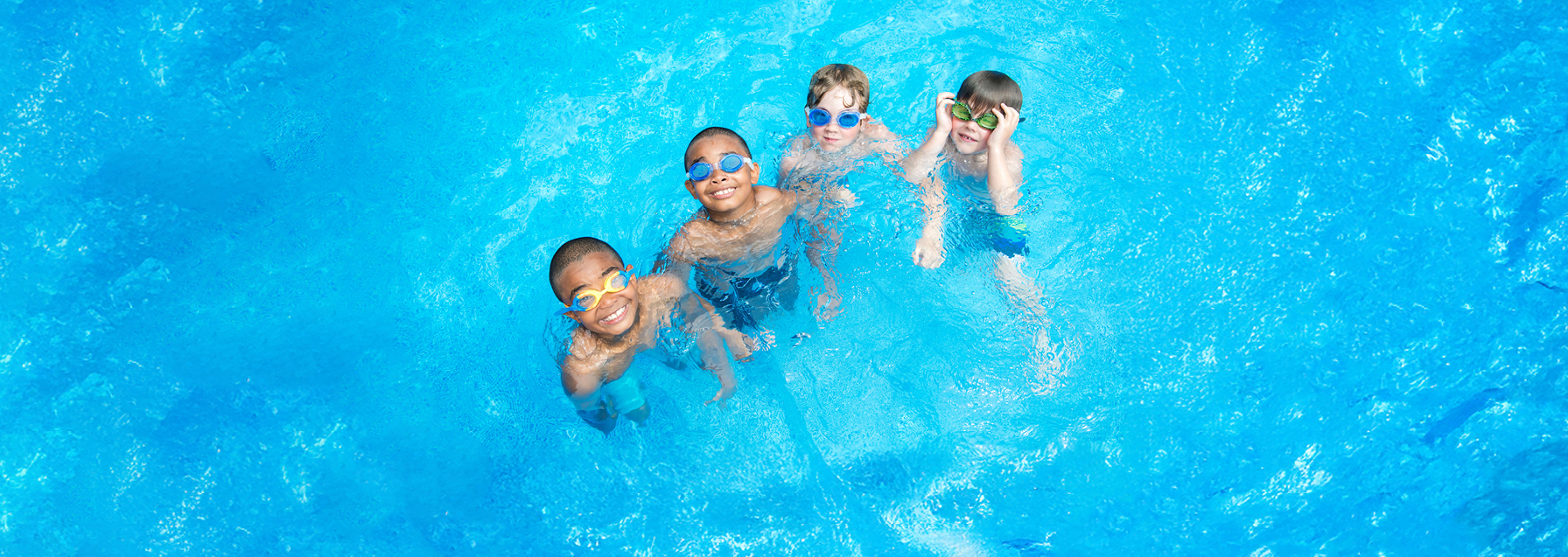 children swimming in a pool smiling