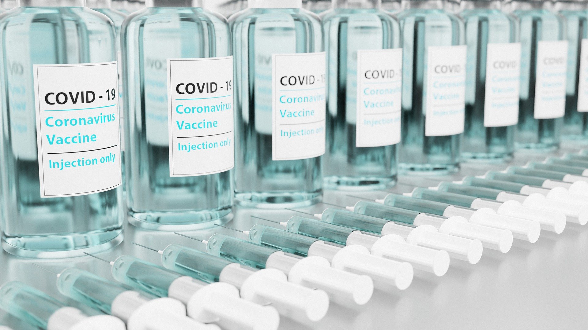 An image of COVID-19 vaccines and syringes.