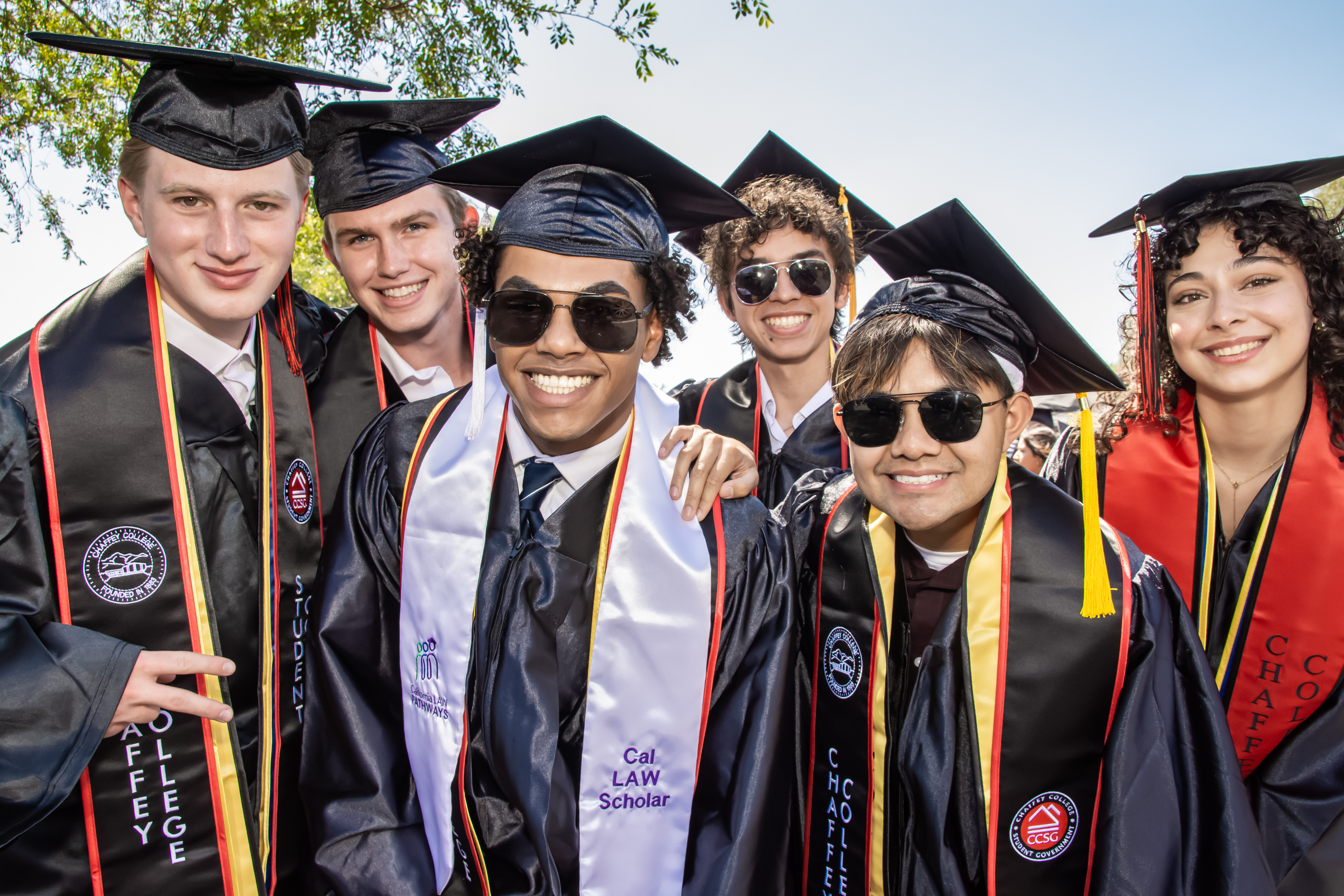multiple studenst standing outside together after graduating