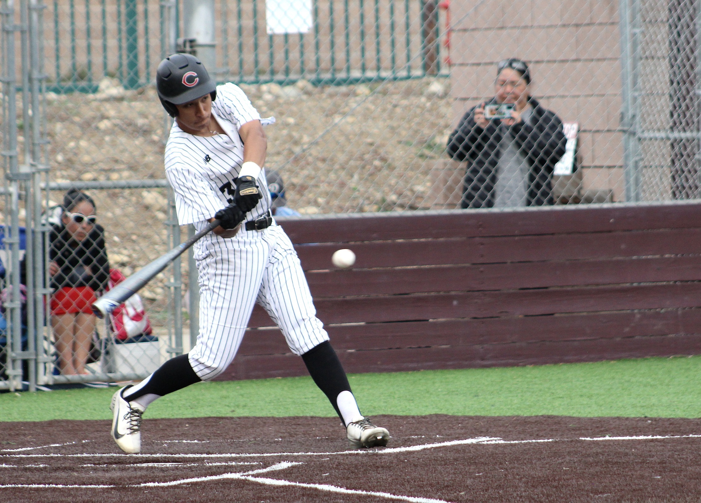 A baseball player hits a ball during a game.