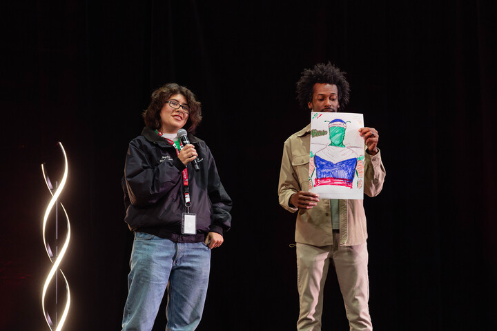 Artivist Nikkolas Smith and a student discuss the student's portrayal of a superhero.