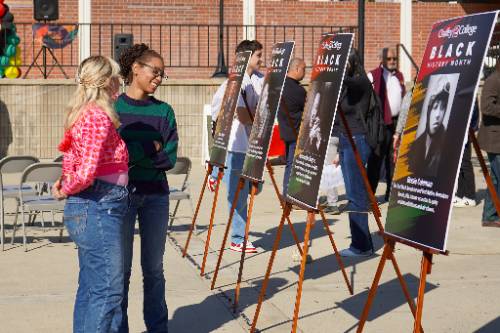 Students look at posters of Black leaders