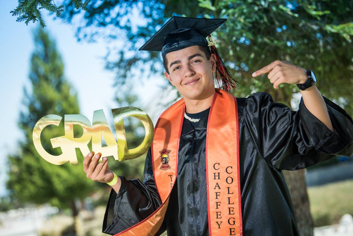 A student poses in a cap and gown