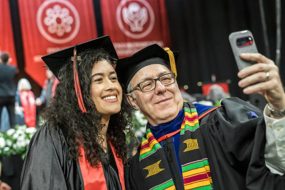 Professor of Business Administration David Karp takes a selfie with one of his students.