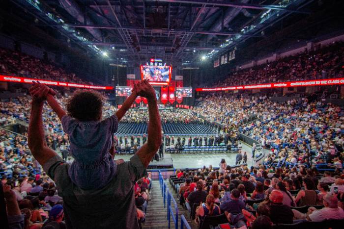 Commencement 2026 2 A man holds his baby on his shoulders at the Toyota Arena commencement ceremony.