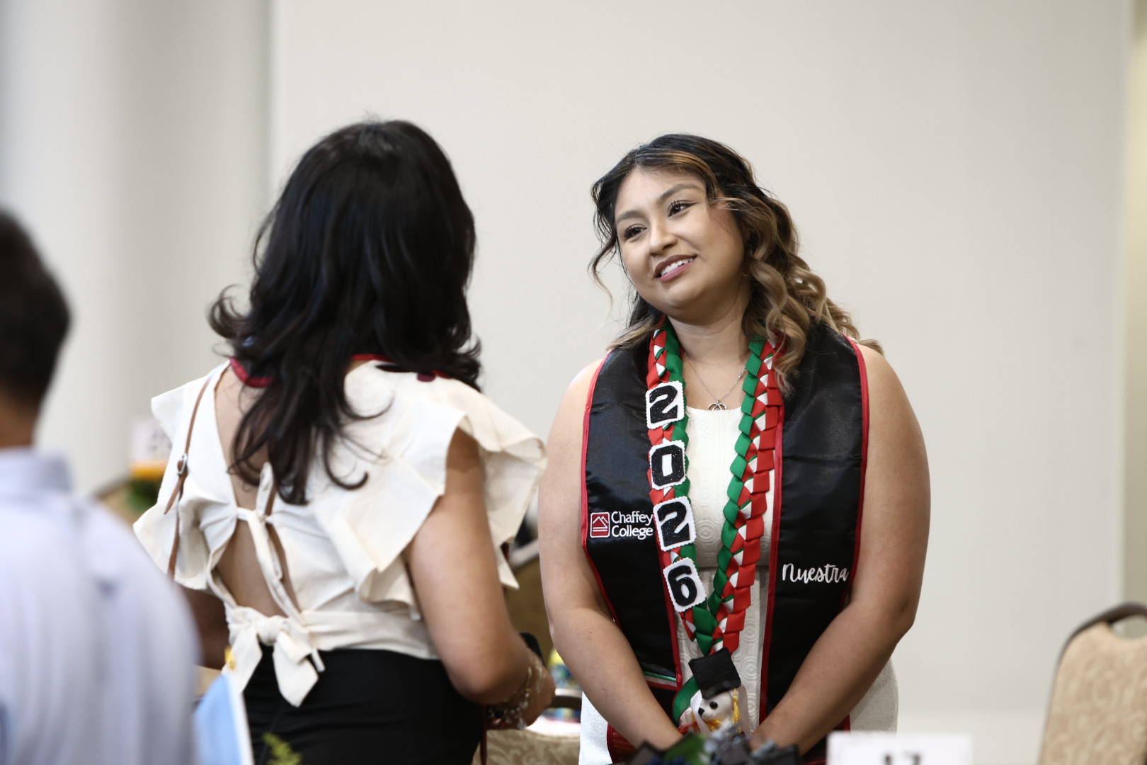 A student smiles at the Nuestra Cultural Graduation