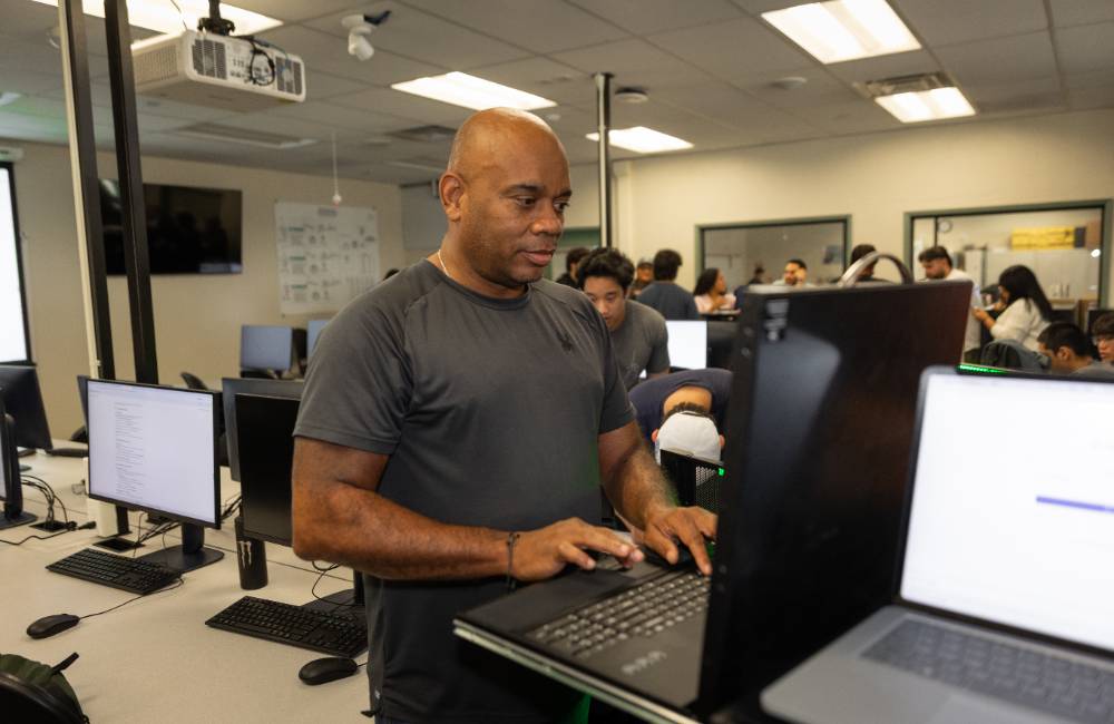 A student works on a laptop in a cybersecurity class.
