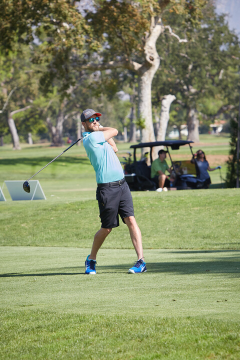 A golf tournament player swings.
