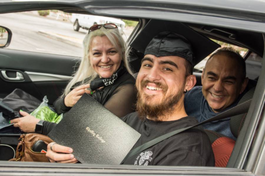 A graduate poses with his diploma cover