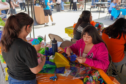 Students make marigold flowers for Dia de los Muertos