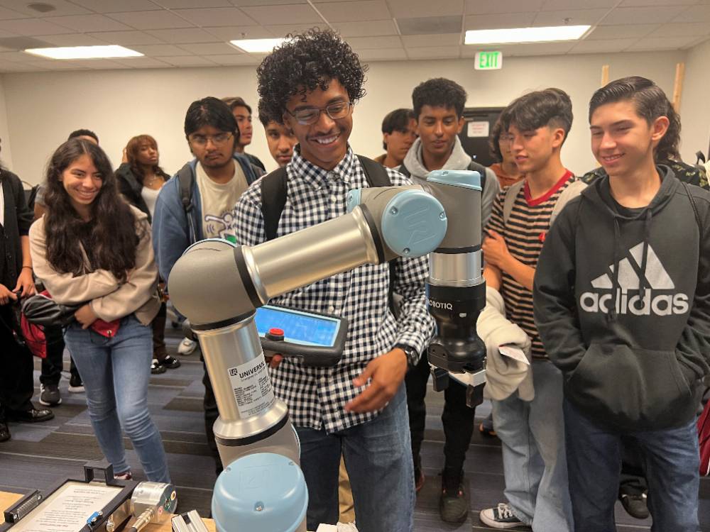 A student programs a robot arm at Manufacturing Day.