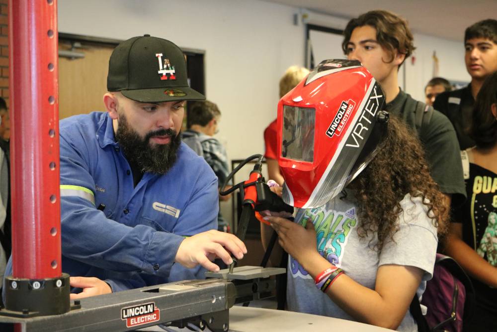 A student participates in a welding simulator demo.