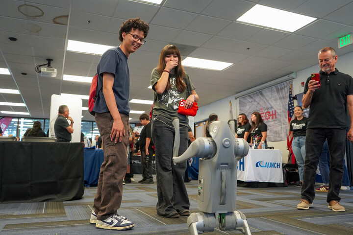 Students react to a robotic dog at Manufacturing Day.
