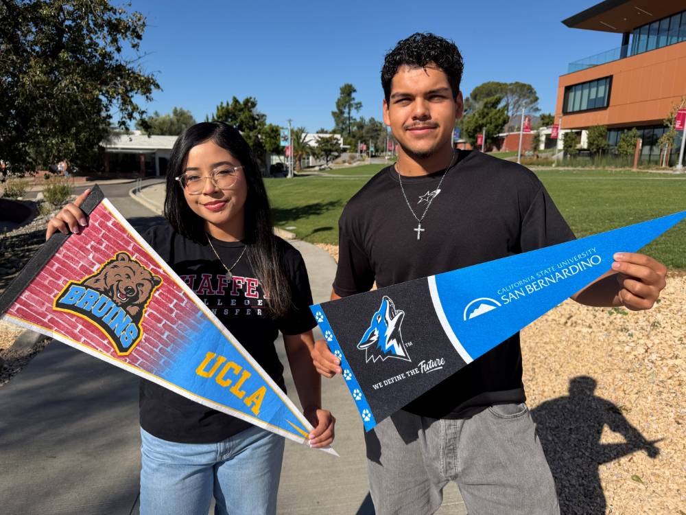 Students pose with pennants for four-year universities.