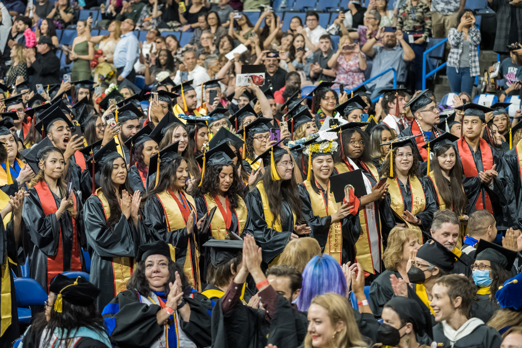 Class of 2023 graduates stand during graduation ceremony.