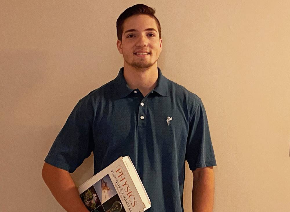 Brayden Diver poses with a physics textbook.