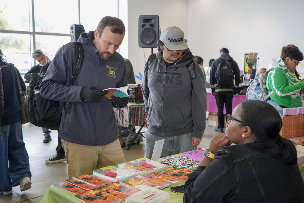Visitors to Chaffey College's Zomics Festival in 2025 browse zines and comic books.