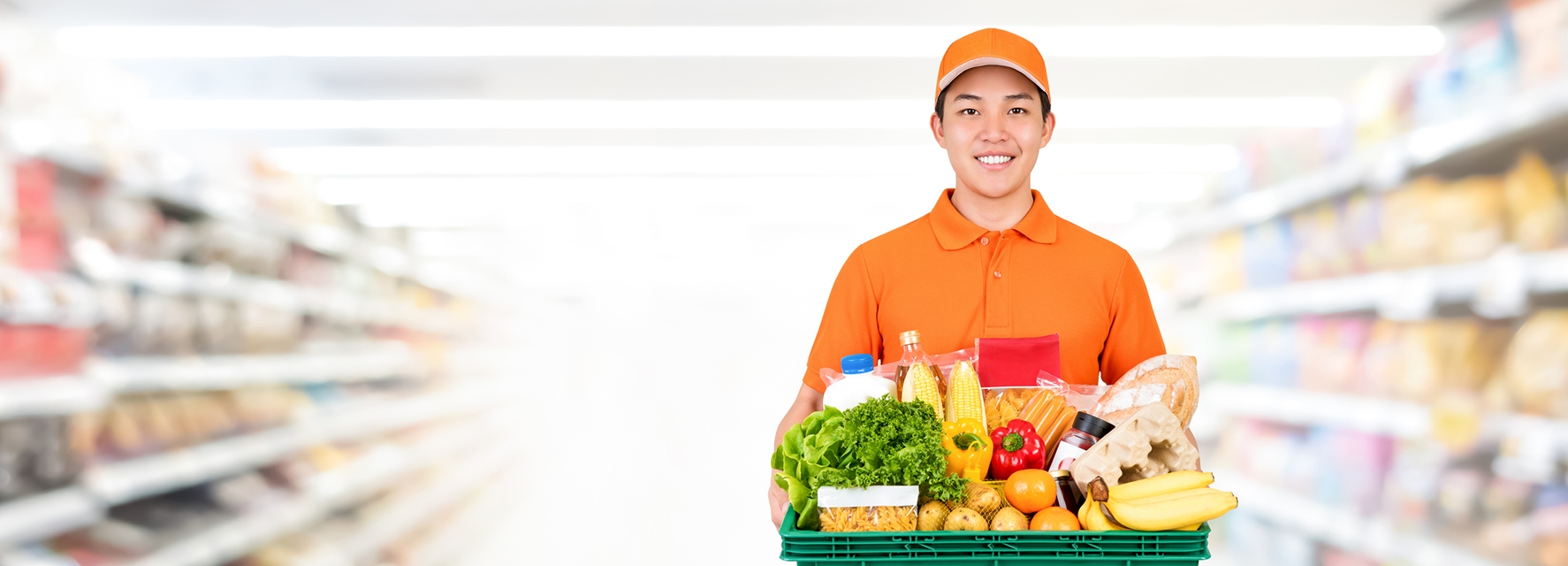 Delivery person wearing orange, holding a basket full of groceries