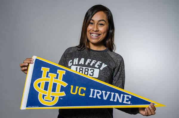 Female Chaffey student smiling and holding UC Irvine's pennant.