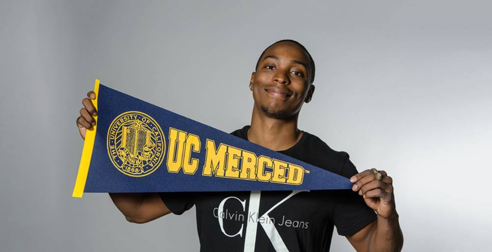 Student holding UC Merced pennant