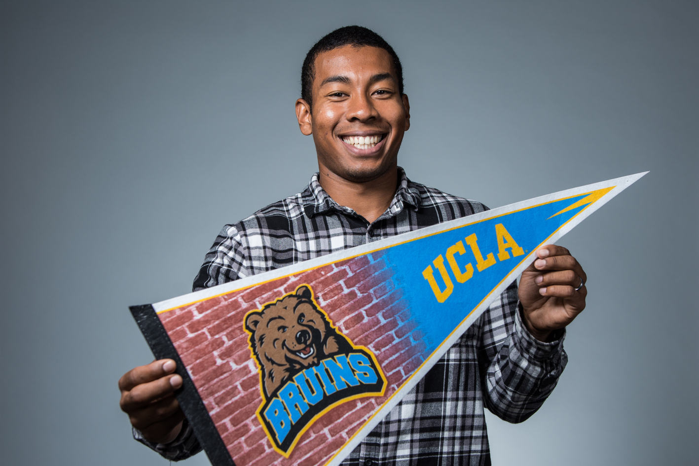 student holding UCLA pennant